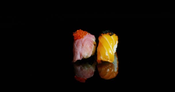 검정색 배경에서 나타나고 그것의 규정식 짭짤한 초밥은 연어와 참치는 전형적인 — 비디오