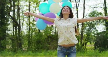 mutlu kadın ormanda renkli balonlar ile iplik ağır çekim video 