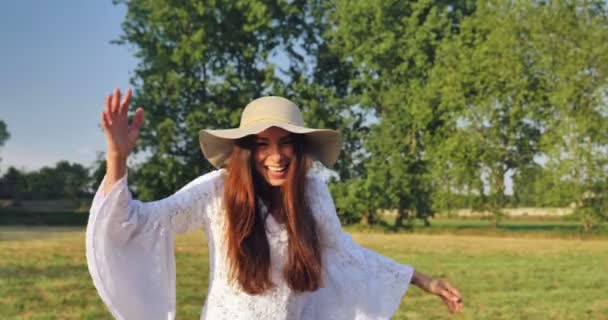 白い夏のドレスと帽子を自然の中の日を楽しんでで女性のスロー モーション ビデオ — ストック動画