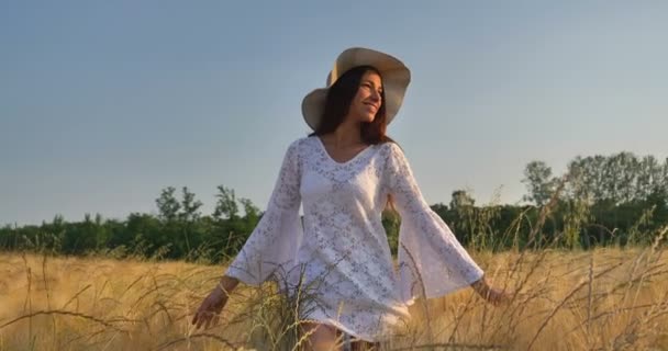白种人妇女白色礼服和帽子走在麦田 农村自然和风景 慢动作视频 — 图库视频影像