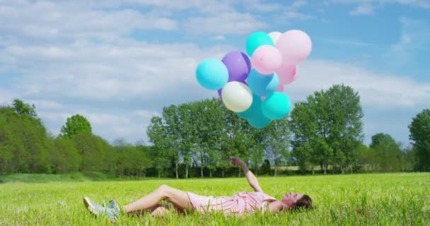 Slow Motion Video Happy Woman Celebrating Colorful Balloons Lying Green — Stock Video