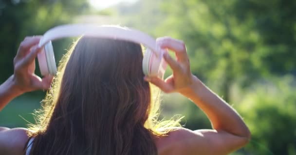 Visão Traseira Vídeo Câmera Lenta Mulher Ouvindo Música Fones Ouvido — Vídeo de Stock