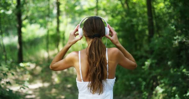 Visão Traseira Vídeo Câmera Lenta Mulher Ouvindo Música Fones Ouvido — Vídeo de Stock