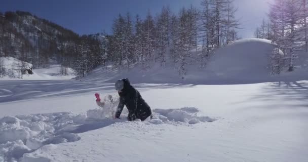 山の中で雪遊びをしている母と娘のビデオ — ストック動画