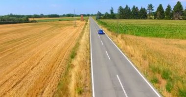 asfalt yol ve mavi araba sürme ile kırsal manzara havadan video 
