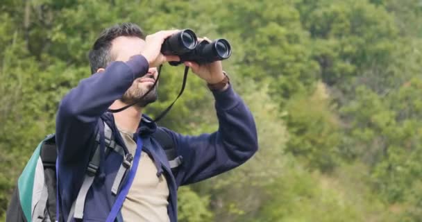 Zeitlupenvideo Eines Wanderers Auf Einem Grünen Hügel Der Fernglas Beobachtet — Stockvideo