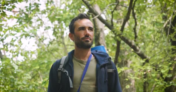 腕を組んでカメラを見て森の旅人男のビデオ — ストック動画