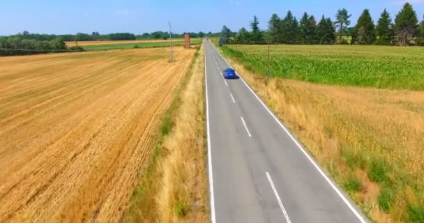アスファルト道路と青い車に乗って田舎の風景の航空ビデオ — ストック動画