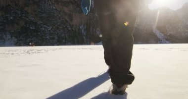 ağır çekim bir kız ormanın içinden ve karda yürür, saf hava, dağın doğada gülümsüyor, sırt çantası hiking ile yürüyor. Kavram: gevşeme, yürüyüş, aşk, saflık, özgürlük