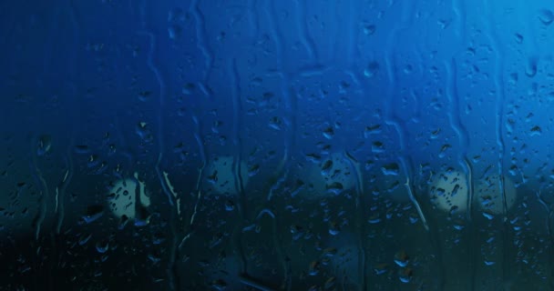 家の窓からガラスの雨を見ることができ 背景をぼかした写真は建物 機械やトラフィックまたは嵐雷雨 — ストック動画
