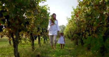 Anne ve küçük kız mutlu oynamak doğada, Anne kucağında bebeği alır ve rahatla, 4 k uhd bir güneş bir aile olarak birlikte olmak mutlu