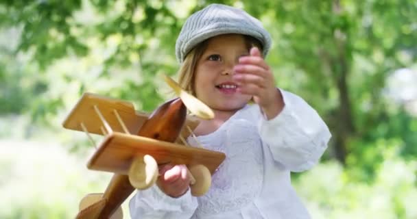par une journée ensoleillée d'été, une petite fille utilise un avion jouet pour s'amuser et être heureuse. Concept d'enfantbois et bonheur et énergie éolienne 