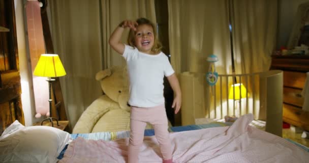 快乐和幸福的小女孩跳上父母的床上玩 快乐的孩子 概念的青年 喜悦和幸福的童年 安全屋和保护的概念 — 图库视频影像