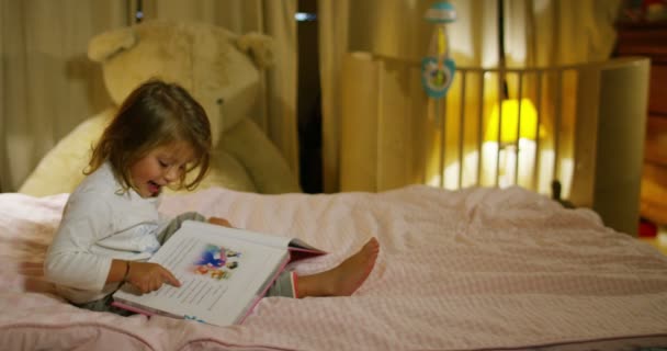 Fröhliche Und Fröhliche Kleine Mädchen Lesen Eine Geschichte Einem Buch — Stockvideo