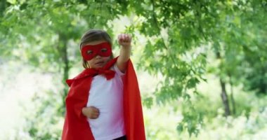 güzel ve mutlu güneşli gün, ifadeler ve renkli doğada uçmayı deneyin bir süper kahraman yapar gibi giymiş küçük bir kız çocuğu mutlu güler. mutluluk, aşk ve doğa kavramı.