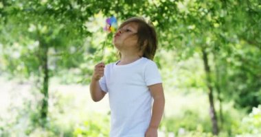 bir güneşli yaz günde küçük bir kız kullanım bir fırıldak bayrak eğlenceli ve mutlu olsun. Childwood ve happinessand enerji rüzgar kavramı