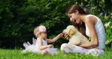 küçük bir kız küçük arkadaşı köpek yavrusu öpüşme küçük dansçı olarak giyinmiş? dostluk, köpekler ve insanlar arasında dostluk çim ve mutluluk kavramı üzerinde oturan altın geri almak. bağlantı