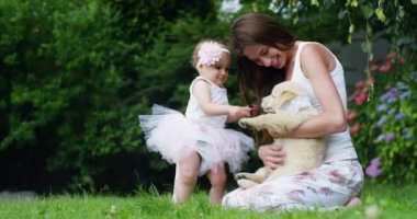 küçük bir kız küçük arkadaşı köpek yavrusu öpüşme küçük dansçı olarak giyinmiş? dostluk, köpekler ve insanlar arasında dostluk çim ve mutluluk kavramı üzerinde oturan altın geri almak. bağlantı