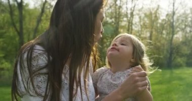 kadın onun bebek yüksek kaldırdı ve ona mutluluk gülümseyen çevresinde dönüş başlar. Kızı parkta oynarken mutlu an anne-baba ve bebek anne zaman harcamak. Anne ve bebek orta çekim