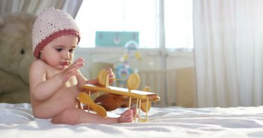 Şirin bir bebek kameraya bakıyor ve mutlu bebek etrafına bakıyor ve silah ile oynamak