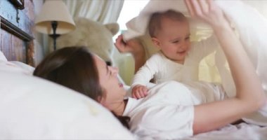 Mutlu anne ve bebek öpüşme ve sarılma, yatak birlikte, annelik konsepti annelik güzel mutlu aile stok Video görüntüleri yavaş dinlenme
