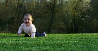 Şirin bir bebek kameraya bakıyor ve mutlu bebek etrafına bakıyor ve silah ile oynamak