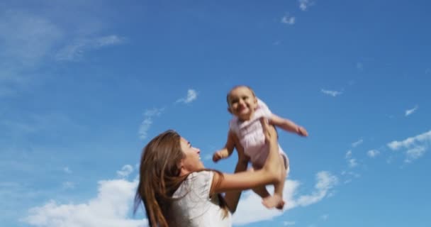 妈妈和小女孩在大自然中快乐地玩耍 母亲把孩子抱在怀里放松一下 很高兴能像一家人一样在 Uhd 的阳光下在一起 — 图库视频影像