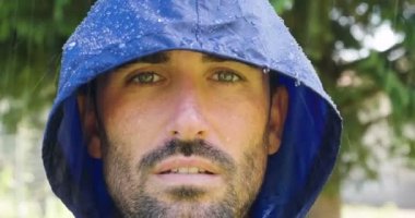 Yağmurda mutlu gülümseyen ve özgürlük, hayaller ve doğa için sevgi soluyan bir adamın portresi. Yaşam tarzı, doğa, özgürlük, yağmur ve mutluluk kavramı