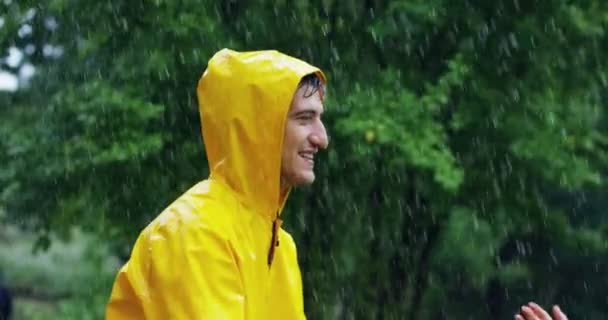 赤と黄色のコートを着て ハグとキスの雨の下に愛のカップルのビデオ — ストック動画