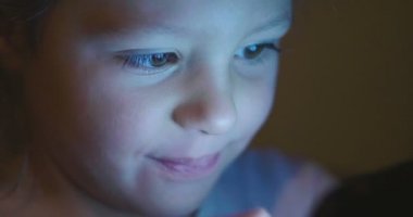 Çocuk akşam veya gece akşam ışığı, e-öğrenme, öğrenme ve basit teknolojileri kavramı ile tablet veya telefon kullanır. Çocuk ve uygulanan teknolojiler futuristik konsepti.