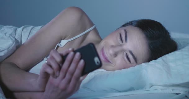 Video Van Brunette Vrouw Bed Liggen Surfen Smartphone — Stockvideo
