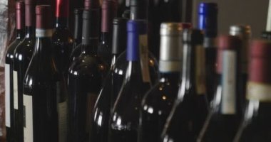 Kaydırıcıyı görünür logo veya marka olmadan kaliteli kırmızı şarap şişeleri üzerinde. Konsept: şarap, şarap salonu, Restoran.