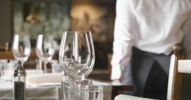 Müşteriler geliyor ve iyi çatal ve gözlük kullanır önce garson tablo lokantada ayarlar. Kavramı: catering, tasarım, romantik yemekler