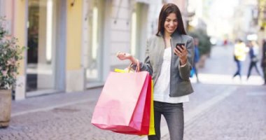 renkli alışveriş torbaları holding, cep telefonu tarama ve gülümseyen alışveriş kadın video 