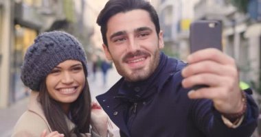 Genç bir çift meşgul veya birlikte, eğleniyor onlar alışveriş ederken, arkadaşları oynamak ve süre onlar gülümseme fotoğraf çekmek. Kavramı: alışveriş, eğlence, dostluk, sevgi ve boş zaman etkinlikleri.