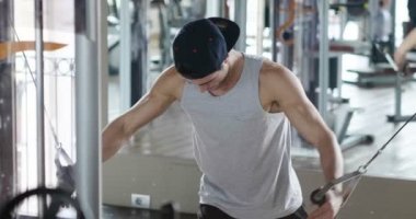 Salondaki, gömleksiz adam vücudu fit kalmak ve kasları tanımlamış olduğunuz için eğitiyor. Atlet ağır ağırlık ve yorgunluk yükseltir. Kavramı: spor, spor salonu, kas ve fitness