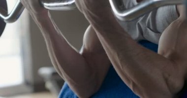 Salondaki, gömleksiz adam vücudu fit kalmak ve kasları tanımlamış olduğunuz için eğitiyor. Atlet ağır ağırlık ve yorgunluk yükseltir. Kavramı: spor, spor salonu, kas ve fitness