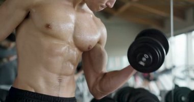 Salondaki, gömleksiz adam vücudu fit kalmak ve kasları tanımlamış olduğunuz için eğitiyor. Atlet ağır ağırlık ve yorgunluk yükseltir. Kavramı: spor, spor salonu, kas ve fitness