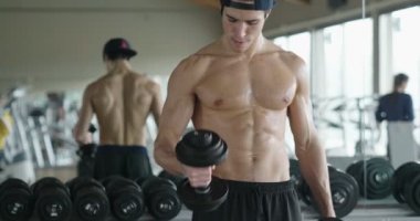 spor salonunda ağır dumbbells ile kas gömleksiz adam video 