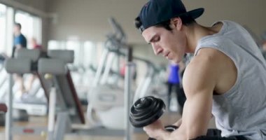 Salondaki, gömleksiz adam vücudu fit kalmak ve kasları tanımlamış olduğunuz için eğitiyor. Atlet ağır ağırlık ve yorgunluk yükseltir. Kavramı: spor, spor salonu, kas ve fitness