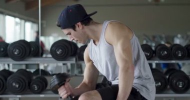 Salondaki, gömleksiz adam vücudu fit kalmak ve kasları tanımlamış olduğunuz için eğitiyor. Atlet ağır ağırlık ve yorgunluk yükseltir. Kavramı: spor, spor salonu, kas ve fitness