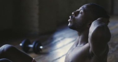 gömleksiz kas Afrikalı adamın dumbbell ile ahşap zemin üzerinde abs egzersizleri yapıyor video