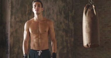 Beyaz adam geçti silah ve kameraya bakarak ile boks torbası ayakta terleme ağır çekim video 