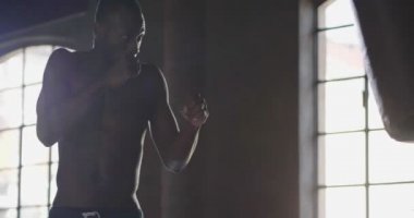 gömleksiz kas boksör adam Boks kum torbası ağır çekim video