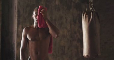 ağır çekim video gömleksiz kas boksör Afrikalı adamın havlu ile terleme yüz temizliği