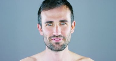 Çok yakışıklı bir adam gülümsüyor ve anti-kırışıklık ve anti-aging vücut bakımı için yüz kremi ve göz kontur koyar ve güzellik bilir. Konsept: Güzellik, krem, güzellik