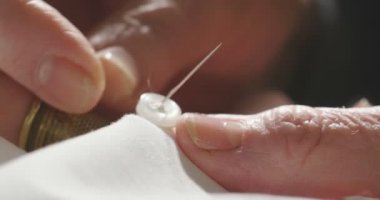 Profesyonel bir dikiş makinesi ile beyaz iplik bir İtalyan couture kumaş dikiş süper ağır çekim, yüksek moda kıyafet terzi diker. Sanayi, gelenek, moda kavramı