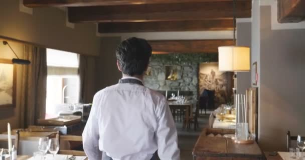レストランを歩くウェイターの男のスローモーションビデオ バックビュー — ストック動画