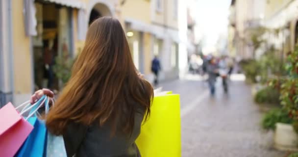 カラフルなショッピング バッグを持ってブルネット買い物客の女性のビデオ — ストック動画