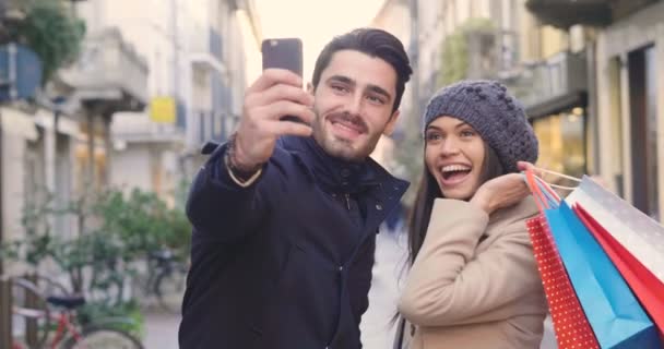 若者のカップルに従事または友人 彼らが買い物しながら一緒に楽しんで遊ぶし 彼らは微笑しながら写真を撮る ショッピング エンターテイメント レジャー — ストック動画